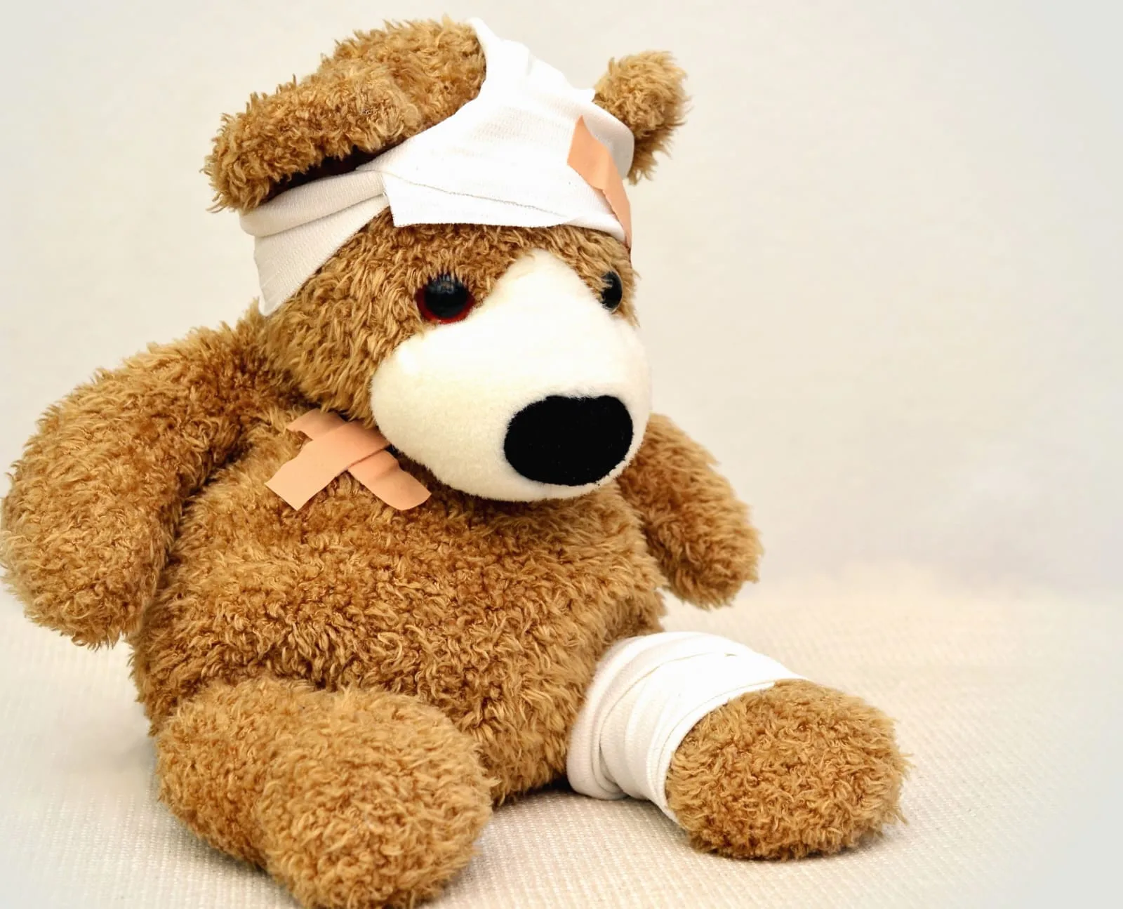 Un ours en peluche avec des pansements.