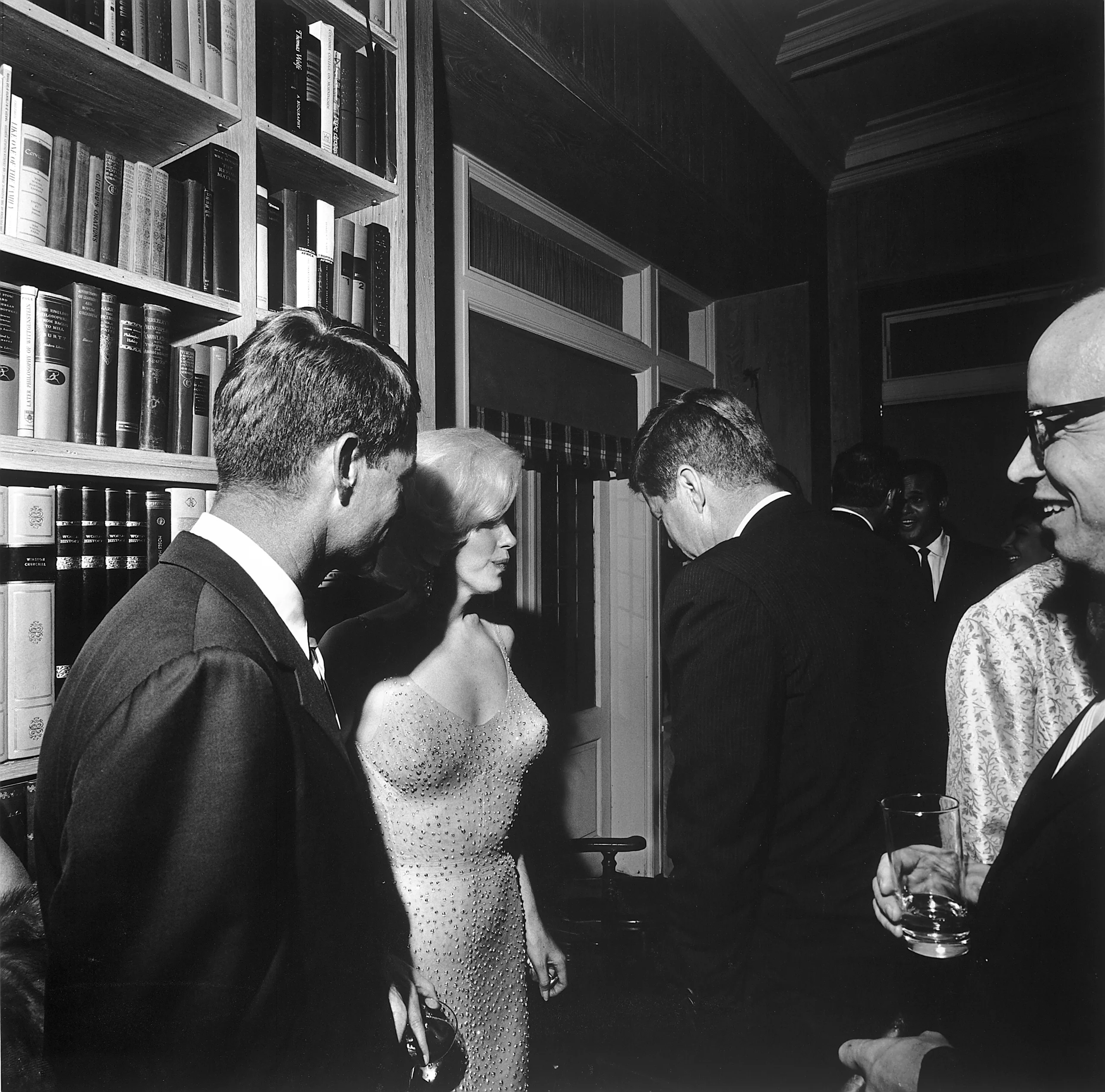Marilyn Monroe debout entre Robert Kennedy et John F. Kennedy.